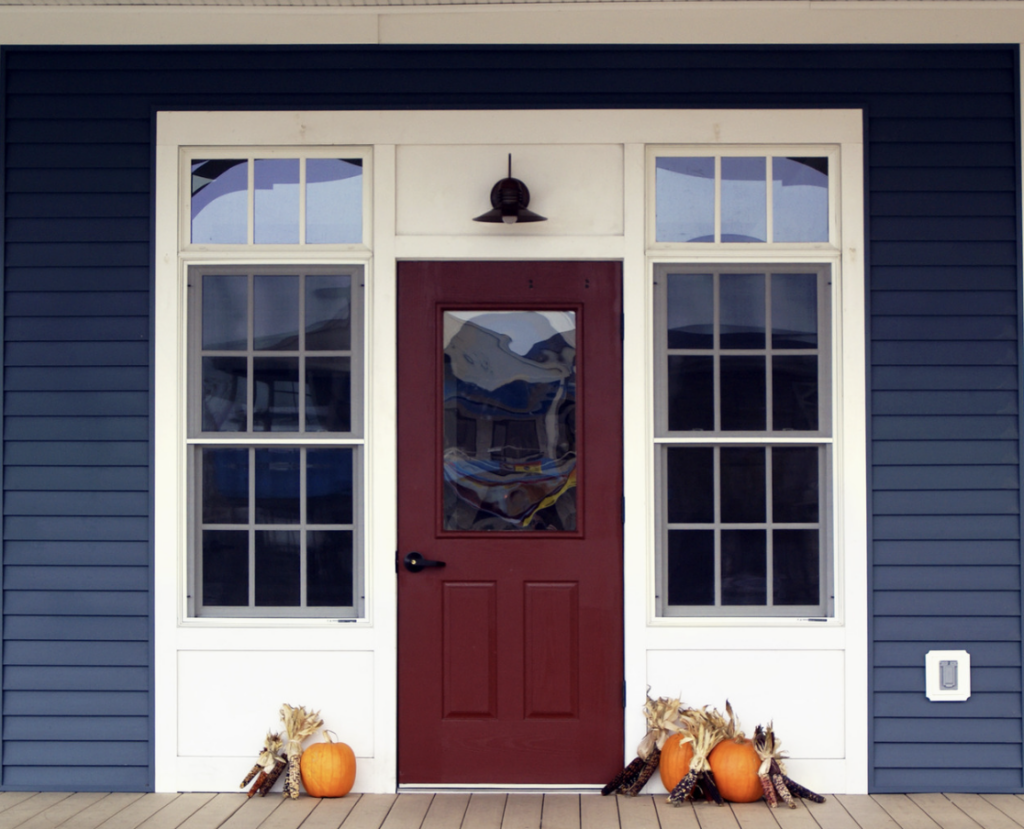 deep red front door with white trim and blue siding